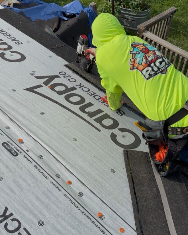 Crew member installing roof underlayment on a DFW home