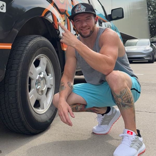 Rich, founder of Rich The Roofer, next to the company truck in Forney, TX